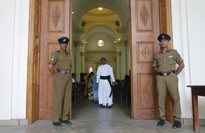 Sri Lankan police officers stand guard at the entrance to St. Lucia's cathedral during a holy mass held to bless victims of the Easter Sunday attacks in Colombo, Sri Lanka, Saturday, May 11, 2019.