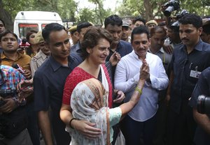 Congress party leader Priyanka Gandhi Vadra, center, accompanied by her husband Robert Vadra greets an elderly voter after casting her vote during the sixth phase of general elections in New Delhi, India, Sunday, May 12, 2019.