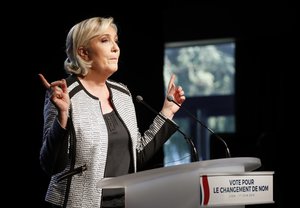 French far right leader Marine Le Pen gestures as she delivers a speech to announce a name-change for her National Front party, in Bron, central France, Friday, June 1, 2018