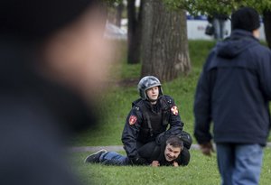 A police officer detain a demonstrator who protests plans to construct a cathedral in a park in Yekaterinburg, Russia, Tuesday, May 14, 2019.