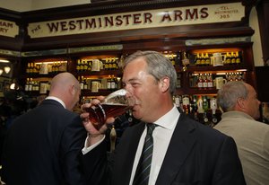 File - Nigel Farage, leader of UK Independence Party and newly elected MEP, drinks a pint of beer in a pub before his post European Elections press conference in central London, Monday, May 26, 2014.