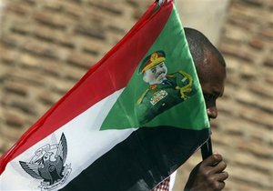 A Sudanese street vender waves Sudanese flags supporting Sudanese  President Omar al-Bashir at a traffic line in Khartoum, Sudan, Thursday, April 8, 2010.