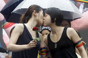 Same-sex marriage supporters kiss outside the Legislative Yuan Friday, May 17, 2019, in Taipei, Taiwan after the legislature passed a law allowing same-sex marriage in a first for Asia.