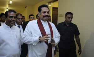 Sri Lanka's disputed Prime Minister Mahinda Rajapaksa, gestures as he arrives for a meeting with his supporting law makers at the parliamentary complex in Colombo, Sri Lanka, Thursday, Nov. 29, 2018.