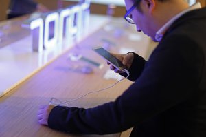 A man checks the Huawei Honor 5X at the Huawei stand during Mobile World Congress wireless show in Barcelona, Spain, Tuesday, Feb. 23, 2016.