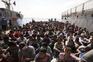 File - Migrants are detained on Wednesday, May 10, 2017 at Abosetta base in Tripoli, Libya. The Libyan coast guard has taken 300 migrants who were trying to reach Europe illegally by boat into custody, following an altercation with a volunteer rescue vessel.