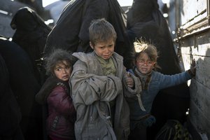 Women and children exit the back of a truck as they arrive to a U.S.-backed Syrian Democratic Forces (SDF) screening area after being evacuated out of the last territory held by Islamic State militants, in the desert outside Baghouz, Syria, Friday, March 1, 2019. (AP Photo/Felipe Dana)