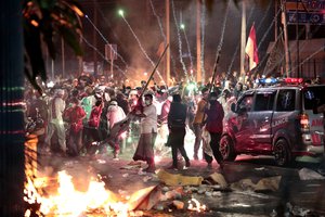 Fire crackers explode near supporters of presidential candidate Prabowo Subianto during clashes with the police in Jakarta, Indonesia, Wednesday, May 22, 2019.