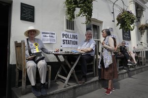 People sit outside The Anglesea Arms Pub which is also serving as a polling station for the European Elections in London, Thursday, May 23, 2019