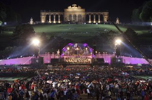 People attend a concert performed by the Vienna Philharmonic Orchestra, conducted by Georges Pretre of France, during the traditional open air concert in the gardens of Schonbrunn Palace in Vienna, Austria, Tuesday, June 3, 2008.