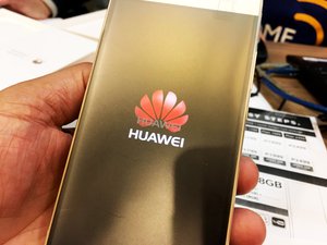 A hand carrying a Huawei P9 gold phone, taken on May 2017.