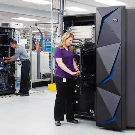 Two employees working with IBM hardware cabinets