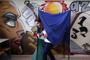 A woman casts his vote at a polling station in Athens on Sunday, May 26, 2019