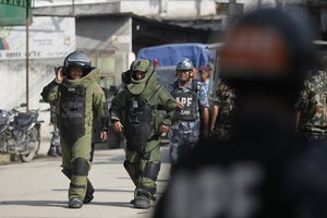 Nepalese bomb squad members get ready to detonate a pressure cooker bomb which was kept inside a school in Kathmandu, Nepal, Tuesday, Sept. 20, 2016.