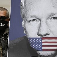 A supporter of Julian Assange, with a poster of the WikiLeaks founder, joins other protesters to block a major road in front of Westminster Magistrates Court in London, Thursday, May 2, 2019. (AP/Frank Augstein)