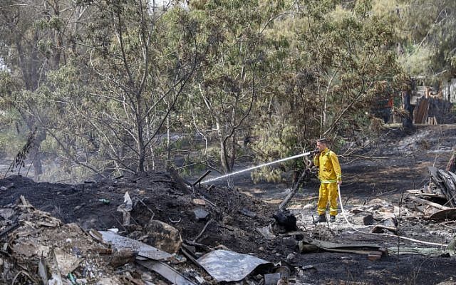 Firefighters extinguish the remains of a fire in Kibbutz Harel, on May 24, 2019. (Noam Revkin Fenton/Flash90)