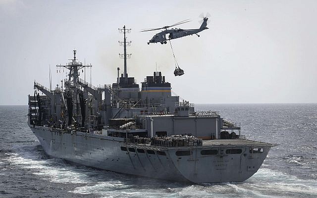 In this Sunday, May 19, 2019, photo released by the US Navy, an MH-60S Sea Hawk helicopter transports cargo from the fast combat support ship USNS Arctic to the Nimitz-class aircraft carrier USS Abraham Lincoln during a replenishment-at-sea in the Arabian Sea.(Mass Communication Specialist 3rd Class Jeff Sherman/US Navy via AP)