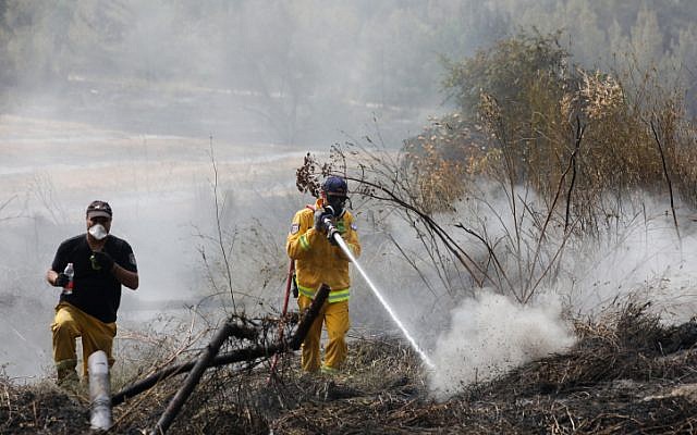 Firefighters extinguish the remains of a fire in Kibbutz Harel, on May 24, 2019. (Noam Revkin Fenton/Flash90)