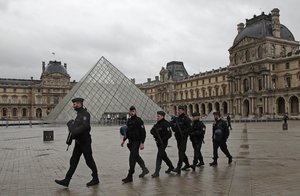 Armed police officers patrol in the courtyard of the Louvre museum near where a soldier opened fire after he was attacked in Paris, Friday, Feb. 3, 2017.