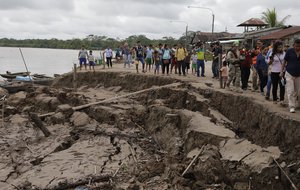 Government officials and members of the press walk on the bank of the Huallaga River after the area was hit by a strong earthquake in Puerto Santa Gema, on the outskirts of Yurimaguas, Peru, Sunday, May 26, 2019.