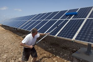 File - Christian Roner, a solar farmer working with the UN Interim Force in Lebanon (UNIFIL), cleans a row of solar panels before the unveiling of UNIFIL’s latest facilities in Nqoura, Lebanon.