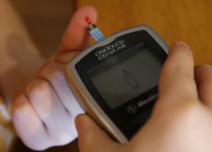 In this photo taken Wednesday, May 13, 2015, Weston Murphy, 5, who has Type 1 diabetes, pricks his finger to test his blood at his home in Plainfield, Ill.