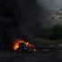 fire of tires burning, black smoke, settlement in the background