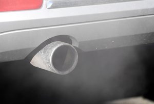 Pollution smoke from cars exhaust pipes in urban traffic