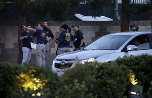 File - FBI agents confer outside of the concert grounds where a mass shooting occurred in Las Vegas, Tuesday, Oct. 3, 2017. Authorities are trying to determine why Stephen Paddock, a 64-year-old high-stakes gambler and retired accountant, killed dozens of people at a country music festival Sunday in Las Vegas.