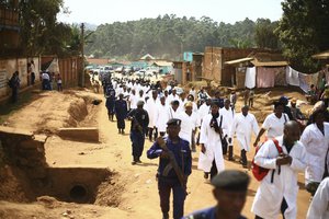 Doctors and health workers march in the Eastern Congo town of Butembo on Wednesday April 24, 2019, after attackers last week shot and killed an epidemiologist from Cameroon who was working for the World Health Organization.