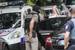 A hooded police officer attend searches at a suspect's home following a blast in Lyon, Monday May 27, 2019 in Oullins, central France