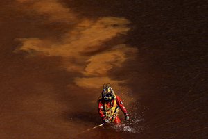 A diver walks out from a toxic man-made lake after a dive search for a third victim near the village of Mitsero outside of the capital Nicosia, Cyprus, Wednesday, May 8, 2019.