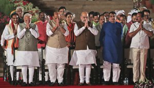 Indian Prime Minister Narendra Modi, left, with newly sworn his cabinet ministers greet the invitees at the end of the swearing in ceremony at the forecourt of presidential palace in New Delhi, India