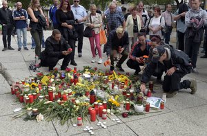 People light candles in Chemnitz, Germany, Monday, Aug. 27, 2018 after a man has died and two others were injured in an altercation between several people of "various nationalities" in the eastern German city on Sunday.