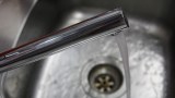 A photo of water running from a tap into a sink.