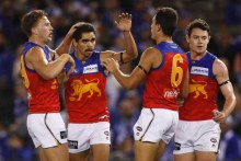 A group of Brisbane Lions players congratulate Charlie Cameron (second left) after a goal.