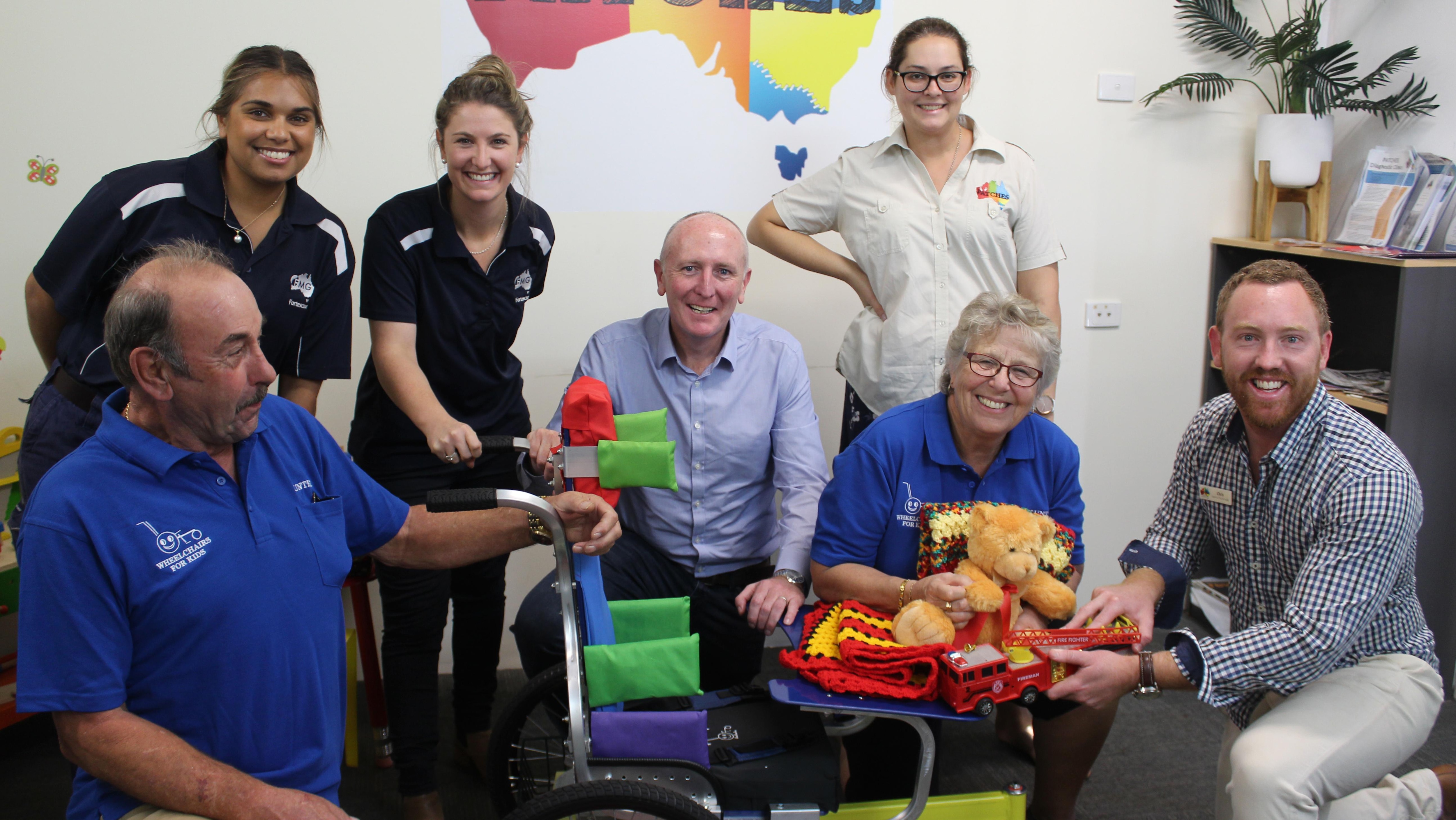 Patches volunteer Tony Clark, Synarah Murphy and Jaylan Smith from FMG, Minister Peter Dawson, Occupational Therapist Jen Leahy, Wheelchair for Kids volunteer Jenny Prince and Clinical Services Manager Chris Briody at Patches presenting a wheelchair.