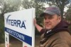 A farmer stands next to a Viterra sign.