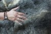 A hand is buried in the soft possum fur of a budbili, traditional Aboriginal cloak.