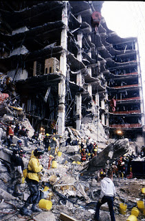 Rescue workers standing in front of building ruins