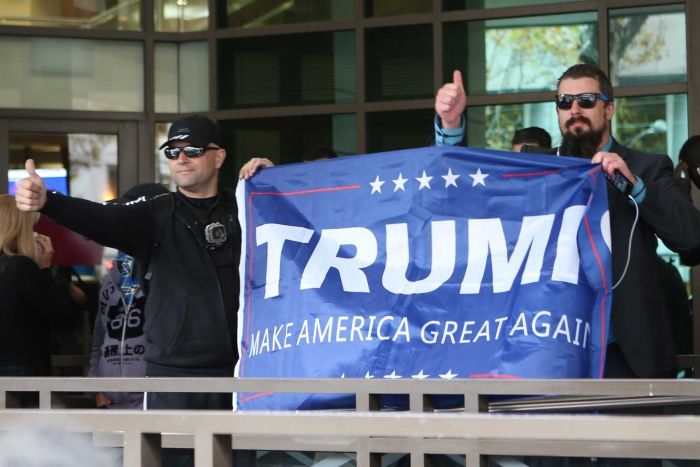 Members of the United Patriots unfold a Donald Trump  banner outside the Melbourne Magistrates' Court.