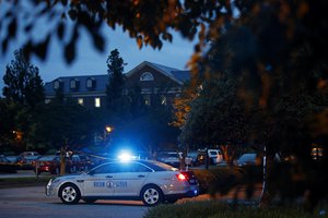 A Virginia State Police vehicle blocks a roadway to a municipal building, seen at top left, that was the scene of a shooting, Saturday, June 1, 2019, in Virginia Beach, Va