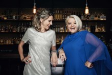 Two women standing in front of a bar