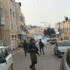 Soldiers invade Al-Khalil, bombarding the city with tear gas and stun grenades. Tear gas is seen in the background.