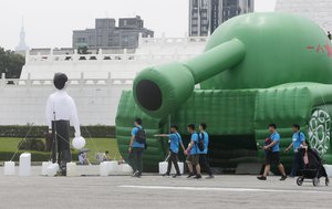 Chinese tourists walk past an inflatable tank man at the Liberty Square of Chiang Kai-shek Memorial Hall in Taipei, Taiwan, Saturday, June 1, 2019.