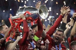 Liverpool's Jordan Henderson lifts the trophy as celebrates with his teammates after winning the Champions League final soccer match between Tottenham Hotspur and Liverpool at the Wanda Metropolitano Stadium in Madrid, Sunday, June 2, 2019. Liverpool won 2-0.