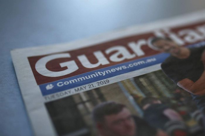 A close up shot of a newspaper with the title "Guardian" in focus.