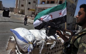 A Free Syrian Army solider aims his weapon at a checkpoint in the northern town of Ariha, on the outskirts of Idlib, Syria, Sunday, June 10, 2012.