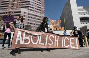 Protesters display a sign that reads "Abolish ICE" during a rally in front of the Immigration and Customs Enforcement facility in downtown Los Angeles on Monday, July 2, 2018.