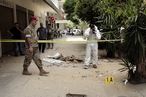 A Lebanese Army investigator takes photos outside a building where clashes erupted between Lebanese troops and a a former member of the Islamic State group, who had engaged in an hours-long shootout with the security forces, in Tripoli, Lebanon, Tuesday, June 4, 2019. Lebanon's interior minister said Tuesday, that a lone gunman who went on a shooting spree in the northern city of Tripoli, killing four security personnel, was working alone.